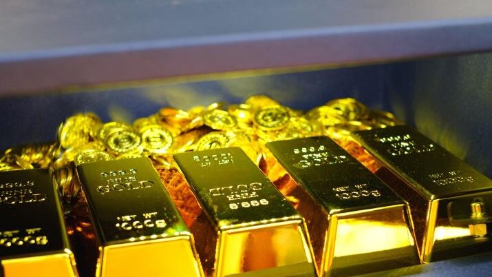 A group of gold bars and coins